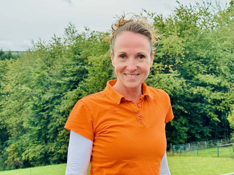 Hund und Halterin kuscheln im warmen Licht